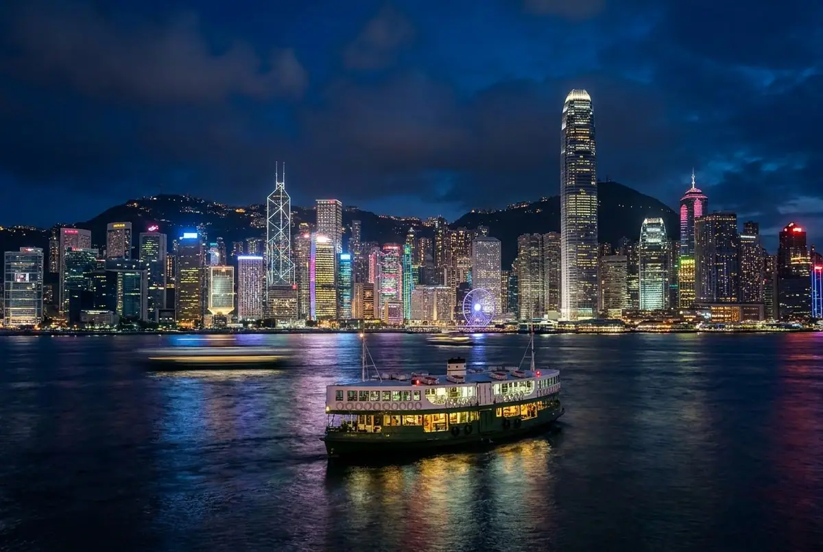 Victoria Harbour and the Hong Kong skyline at night with a Star Ferry crossing