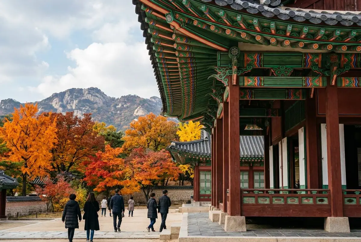 Gyeongbokgung Palace in Seoul with colourful painted eaves and mountains behind in autumn