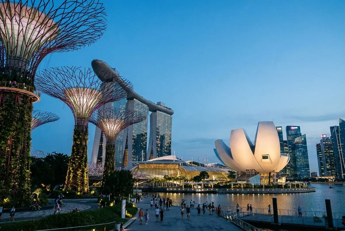 Singapore's Marina Bay waterfront at dusk with garden structures and the city skyline